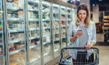 woman shopping the grocery store pushing cart