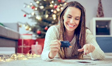 woman smiling at phone when typing in her debit card