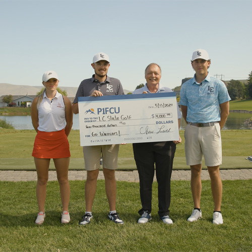 four people stand with large check written to lc state golf