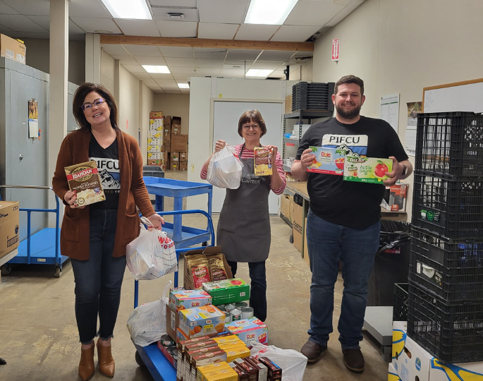 two p1fcu employees with another person at the colfax foodbank