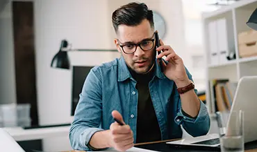 man taking notes while on phone