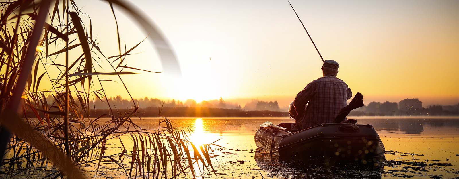 Person on boat fishing at sunrise